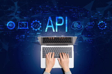 api - application programming interface concept with person using a laptop computer