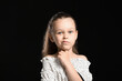 © Pixel-Shot - Portrait of thoughtful little girl on black background