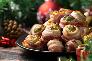 Wall Mural - Christmas Streaky bacon wrapped Brussel sprouts with decoration, gifts, green tree branch on wooden rustic table