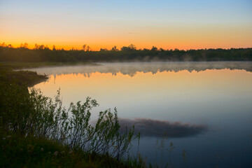 Wall Mural - Fog over the lake on a beautiful summer evening