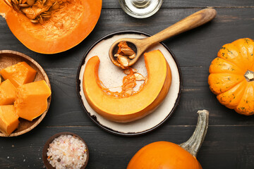 Composition with ripe cut pumpkin on dark wooden background, closeup