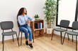 © Krakenimages.com - Young latin woman looking watch sitting on chair at waiting room