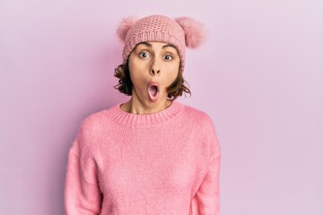 Poster - Young brunette woman wearing cute wool cap afraid and shocked with surprise expression, fear and excited face.