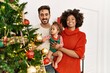 © Krakenimages.com - Couple and daughter smiling confident decorating christmas tree at home