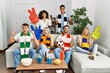 © Krakenimages.com - Group of friends supporting football team watching tv al home sitting on the sofa screaming proud, celebrating victory and success very excited with raised arms