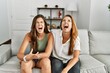 © Krakenimages.com - Mother and daughter together sitting on the sofa at home angry and mad screaming frustrated and furious, shouting with anger. rage and aggressive concept.