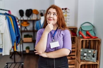 Poster - Young redhead woman working as manager at retail boutique with hand on chin thinking about question, pensive expression. smiling with thoughtful face. doubt concept.