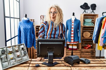 Poster - Middle age blonde woman working as manager at retail boutique making fish face with lips, crazy and comical gesture. funny expression.