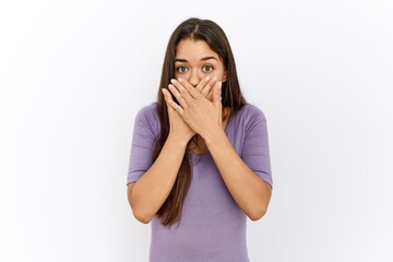 Canvas Print - Young brunette woman standing by isolated background shocked covering mouth with hands for mistake. secret concept.