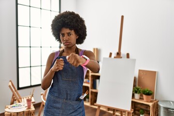 Canvas Print - Young african american woman with afro hair at art studio punching fist to fight, aggressive and angry attack, threat and violence