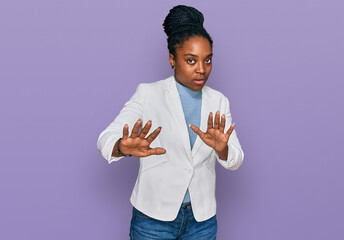 Canvas Print - Young african american woman wearing business clothes doing stop gesture with hands palms, angry and frustration expression