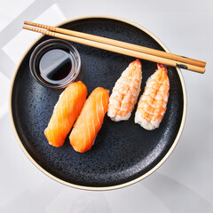  Plate of two shrimp nigiri sushi and two salomon nigiri sushi isolated on white background