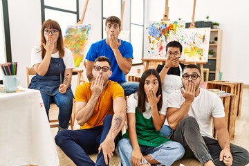 Sticker - Group of people sitting at art studio covering mouth with hand, shocked and afraid for mistake. surprised expression