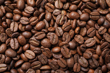 Pile of roasted coffee beans as background, top view