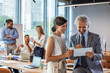 © Dragana Gordic - Happy business colleagues in modern office using tablet. Young business couple working on tablet in modern office. Shot of a young businessman and businesswoman using a digital tablet