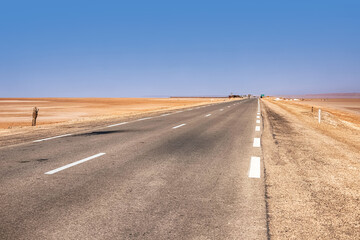 An asphalt road that runs along the Sahara Desert. Sahara Desert, Tunisia