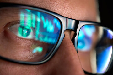 Wall Mural - focused crypto trader analyst wearing eyeglasses working looking at computer screen reflecting in gl