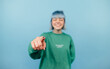 © bodnarphoto - Positive hipster girl in green clothes and turquoise hair shows finger to camera and laughs, focus on fingers.