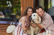 © Seventyfour - Portrait of happy couple embracing dog outdoors and looking at camera in Summer, copy space