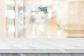 Wall Mural - Empty white table top, counter, desk over blur store with bokeh background, White marble stone table, shelf and blurred shop for food, product display mockup, 