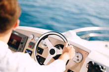 Man In A White Shirt Is Driving A White Motor Boat. Close-up