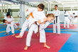 © JackF - Kids in kimono exercising throws during aikido training. Their teacher stadning nearby and watching.