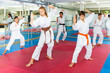 © JackF - Focused children trying new martial moves in a practice during karate class in gym with their coach