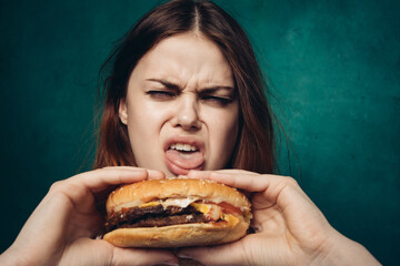 Wall Mural - woman eating hamburger fast food snack close-up