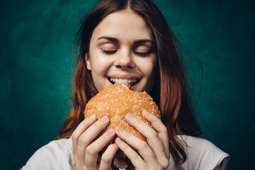 Wall Mural - woman eating hamburger fast food snack close-up