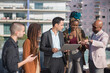 © KAMPUS - Business people discussing matters on terrace roof. Men and women of different nationalities on terrace roof, using laptop, talking. Work, modern technology, team concept