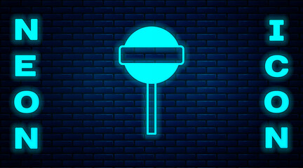 Poster - Glowing neon Lollipop icon isolated on brick wall background. Food, delicious symbol. Vector