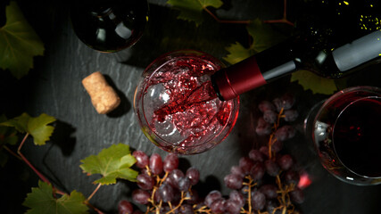 Wall Mural - Pouring red wine, black stone background. Top view.