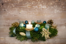 Advent Wreath Series Number One With A Lit Candle, Blue Christmas Baubles And Decoration On A Rustic Wooden Snowy Background, Fourth Sunday, Copy Space, Selected Focus