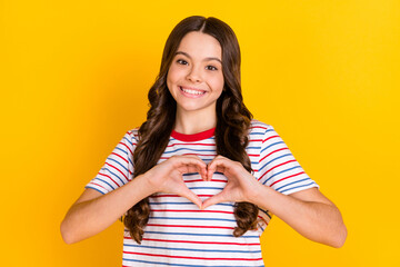 Wall Mural - Photo of young girl happy positive smile show fingers heart symbol love like valentine day isolated over yellow color background