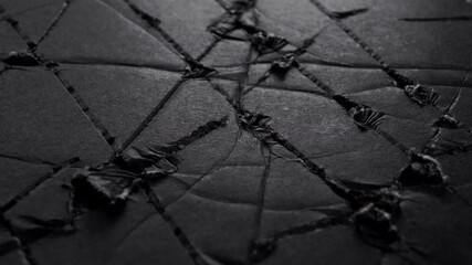 Wall Mural - Black scratched torn worn paper. Abstract damaged surface. Macro. Slow rotation