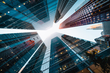 Business and finance concept, looking up at high rise office buildings at sunset in the financial district of a modern metropolis.