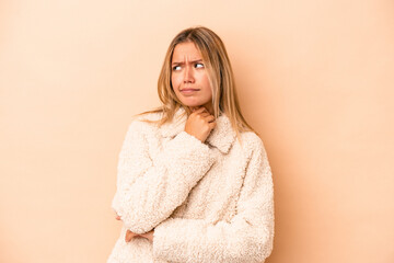 Wall Mural - Young caucasian woman isolated on beige background suffers pain in throat due a virus or infection.