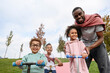 © Westend61 - Smiling father standing with playful children at park