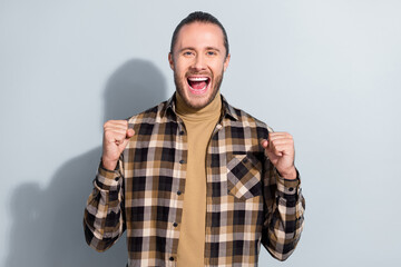 Sticker - Photo of young astonished guy rejoice victory fists hands watch football match isolated over grey color background