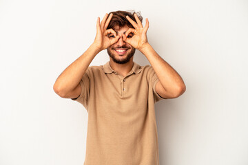 Wall Mural - Young mixed race man isolated on grey background showing okay sign over eyes