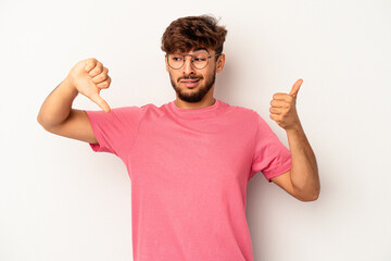 Young mixed race man isolated on grey background showing thumbs up and thumbs down, difficult choose concept