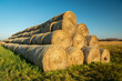 Large stack of hay bales and blue sky