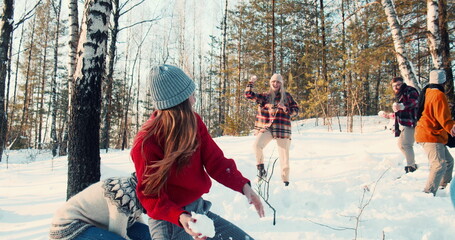 CHRISTMAS FUN. Happy group of diverse friends play snowball fight at amazing snowy winter forest with dog slow motion.