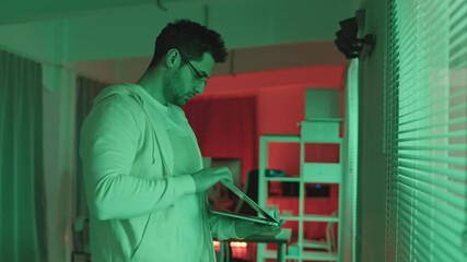 Wall Mural - medium slowmo shot of young bearded it specialist in casualwear and eyeglasses shutting down laptop 