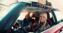 Three Happy Young Excited Multiethnic Women Posing, Smiling At Camera In Fancy Red Car On Snowy Winter Road Slow Motion.