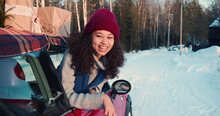 Cinematic Shot, Three Happy Young Beautiful Multiethnic Women Wave At Camera In Red Car On Snowy Winter Road Slow Motion