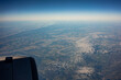 Landschaft mit Schäfchenwolken aus einem Flugzeug-Fenster beobachtet