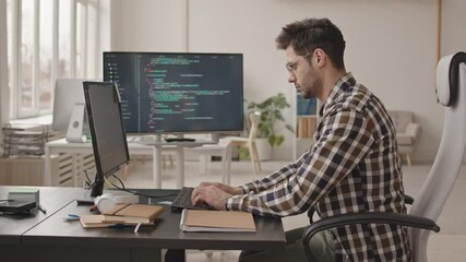 Wall Mural - side-view stab shot of young bearded software engineer or system administrator in casualwear and eye