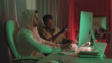 Wall Mural - stab slowmo shot of two multiethnic software developers or hackers talking while working on pc compu