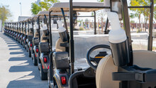 A Row Of Electric Golf Carts On A Golf Course.